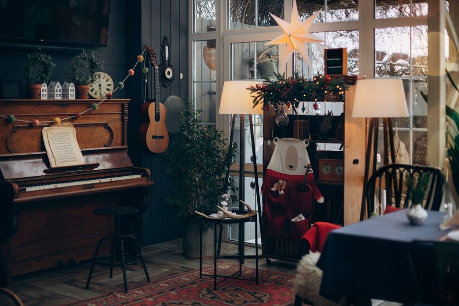 Warm and festive living room featuring a piano, decorations, and a Christmas star.